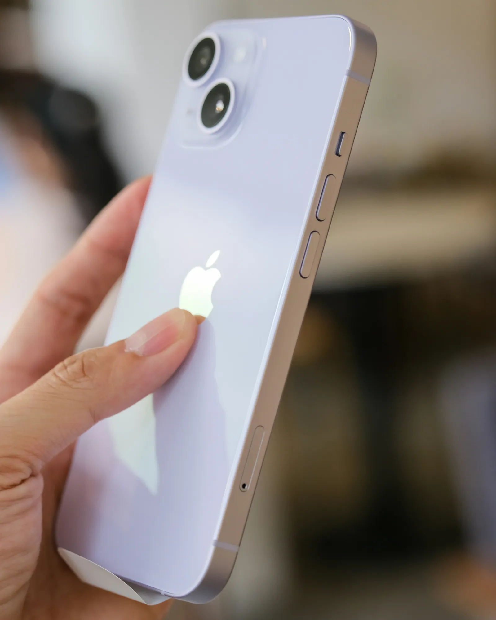 a hand holding a white cell phone